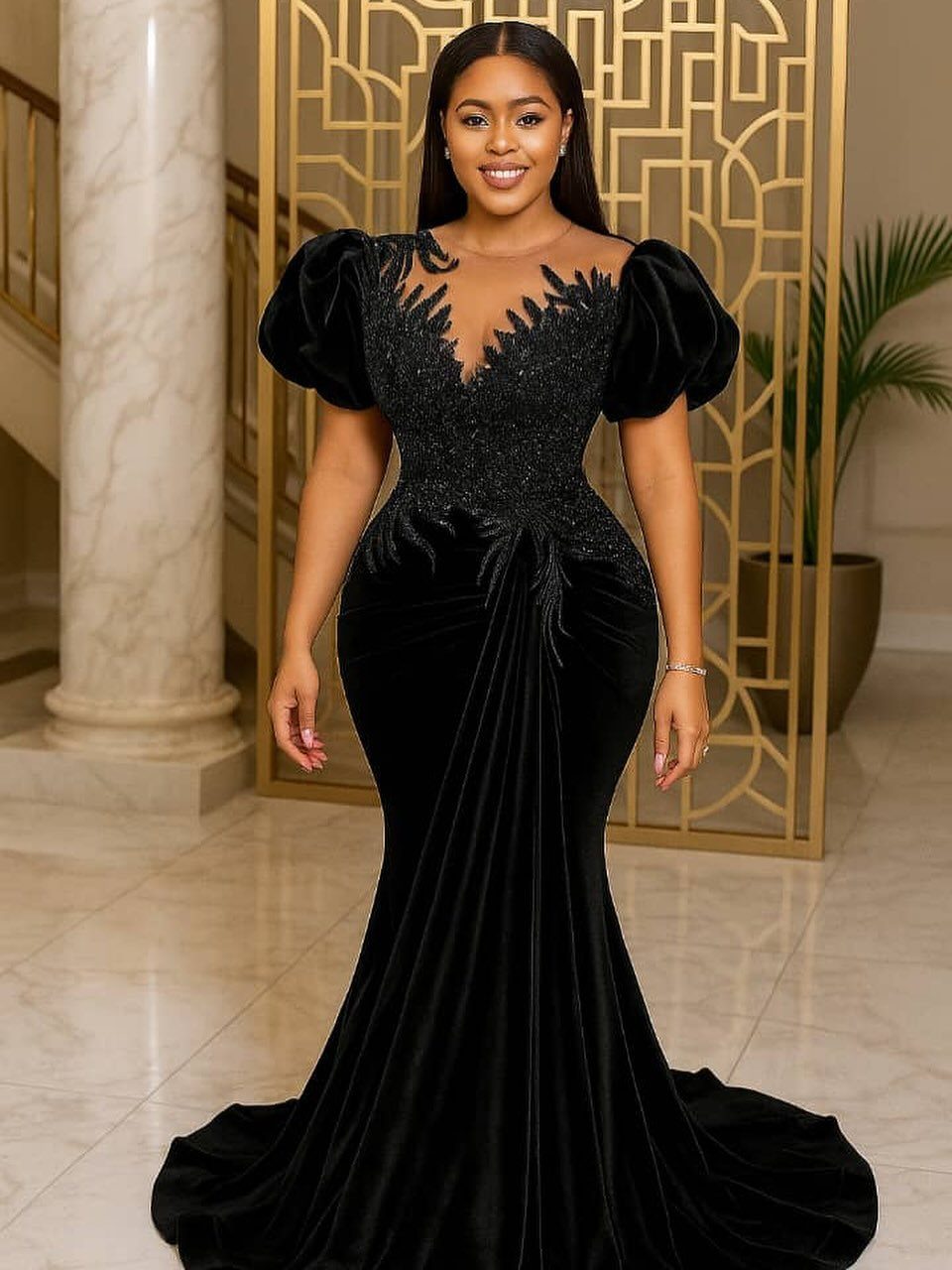Woman in a black velvet mermaid gown with beaded bodice and puffed sleeves.