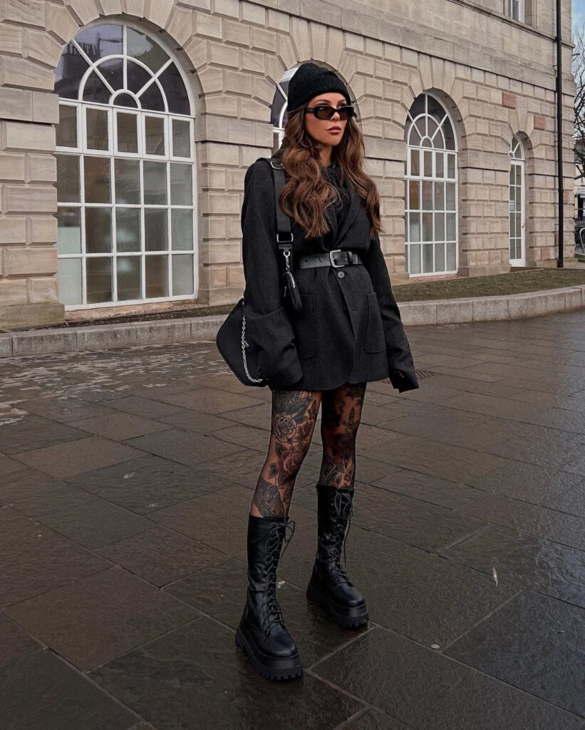 Woman wearing chunky black lace-up combat boots and an all-black grunge outfit.
