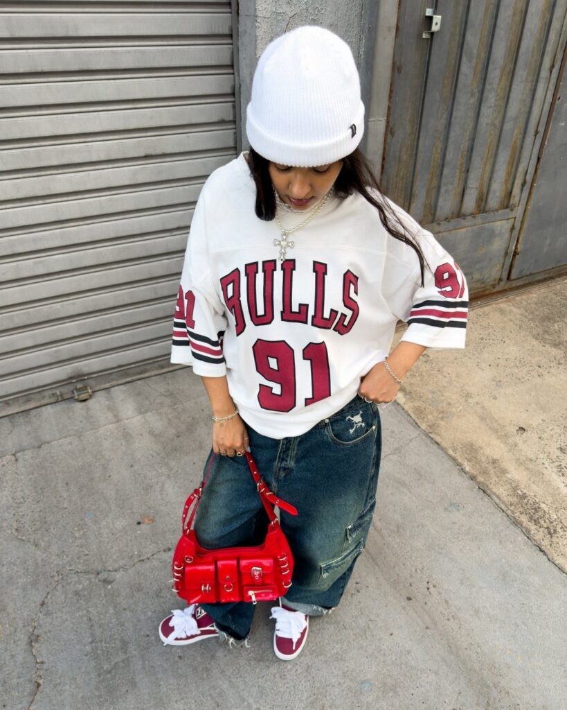 Person wearing red sneakers, blue denim jeans, and a white Bulls jersey.