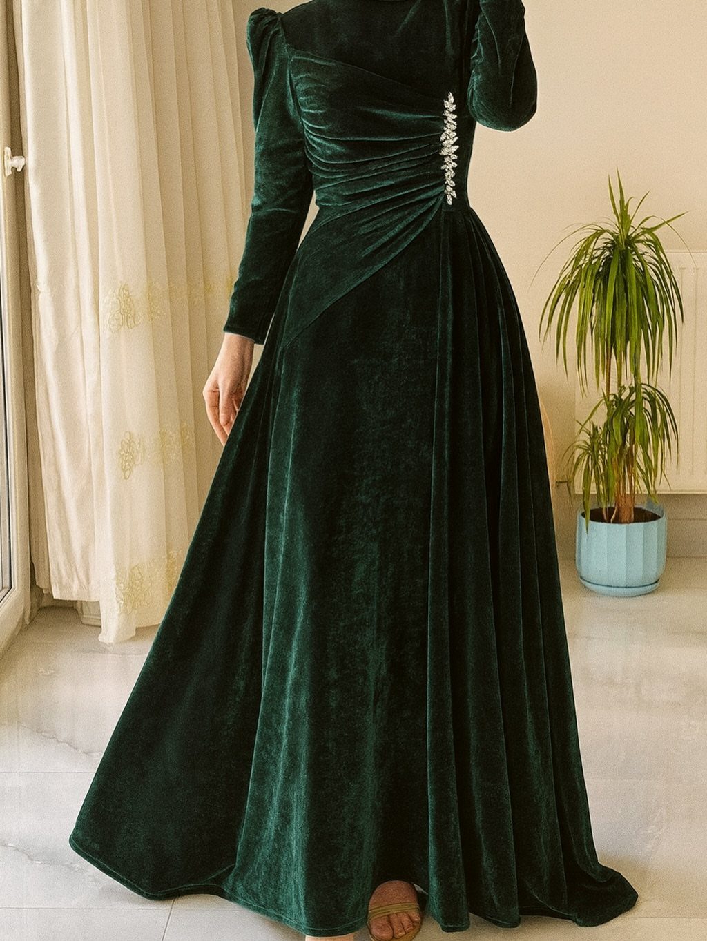 Dark green velvet floor-length dress with long sleeves and silver waist detail.