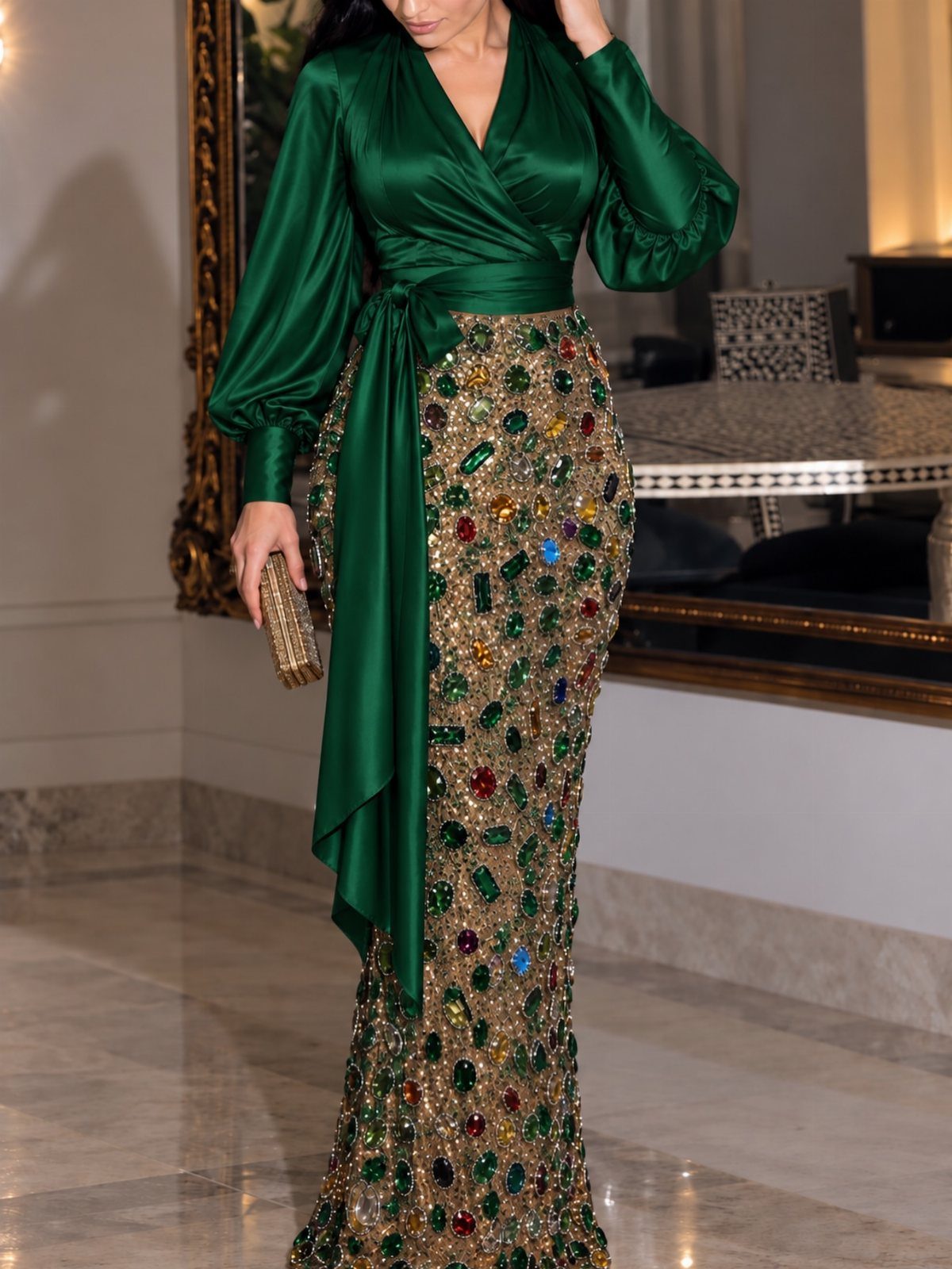Woman in a luxury emerald green evening gown with a crystal embellished skirt.