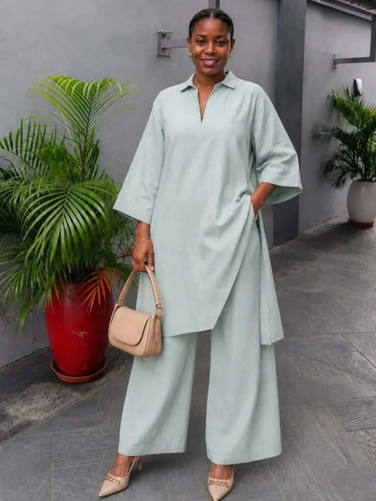 Woman wearing a mint green tunic and matching wide-leg tailored trousers with beige heels.