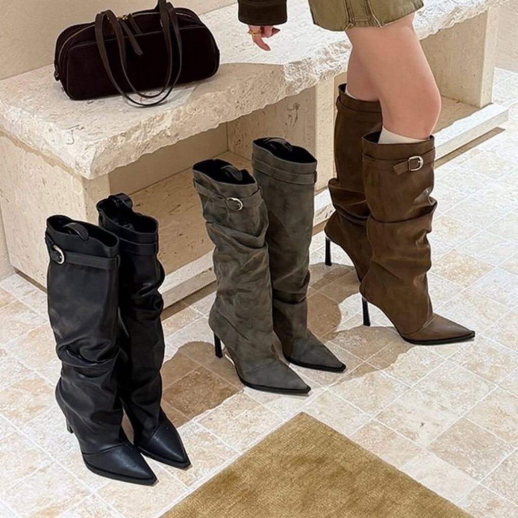Mid-calf heeled boots in black, grey, and brown on a stone floor.