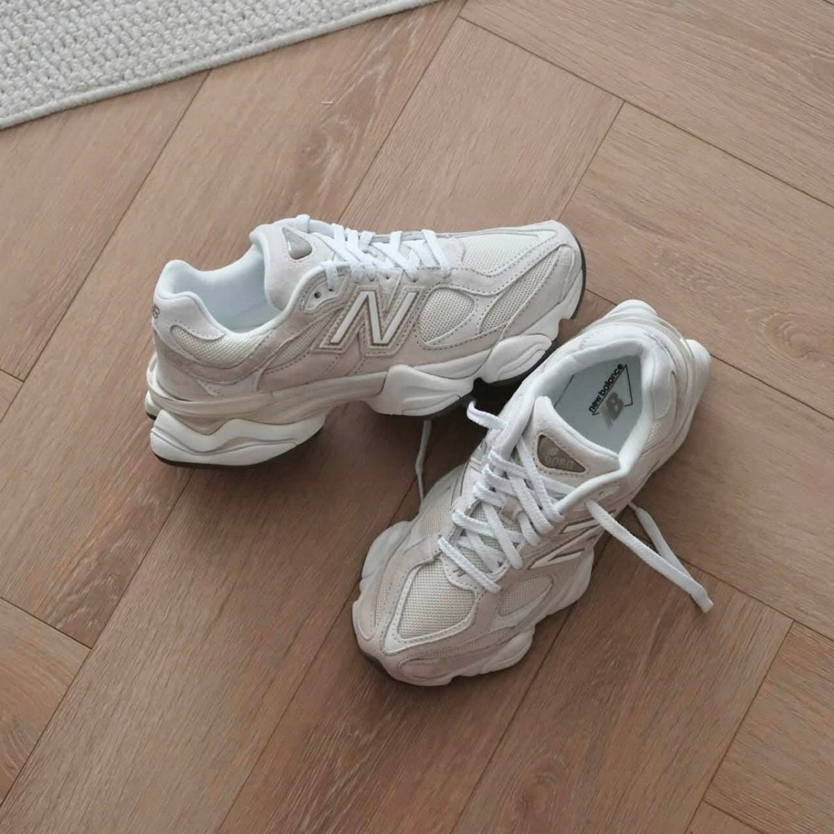 New Balance 9060 sneakers in sea salt and moonbeam on wooden flooring