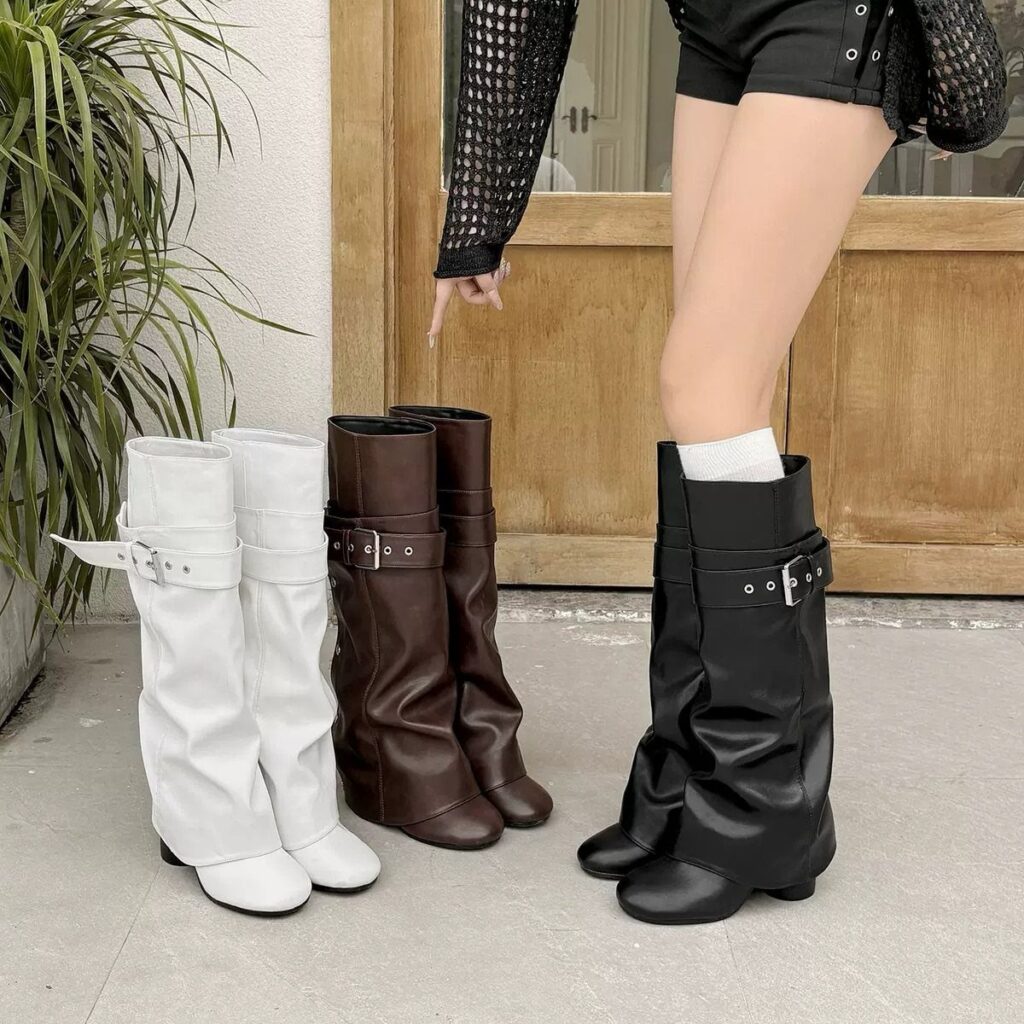 Slouchy knee high boots in white, brown, and black colors on a concrete floor.