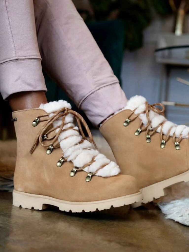 Tan suede lace-up boots with white faux-fur lining and thick rubber soles.